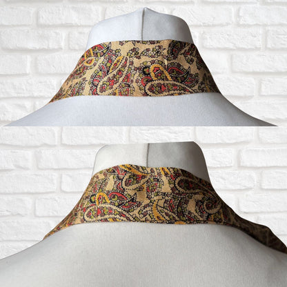 Decorative necktie  with paisley pattern on a mannequin against a white brick