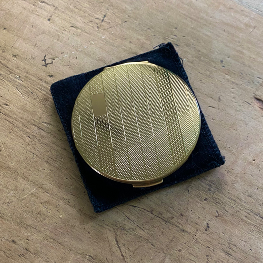 Fine spot and stripe design on gold tone powder compact