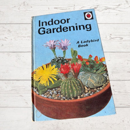 Book titled 'Indoor Gardening' by Ladybird on a wooden surface