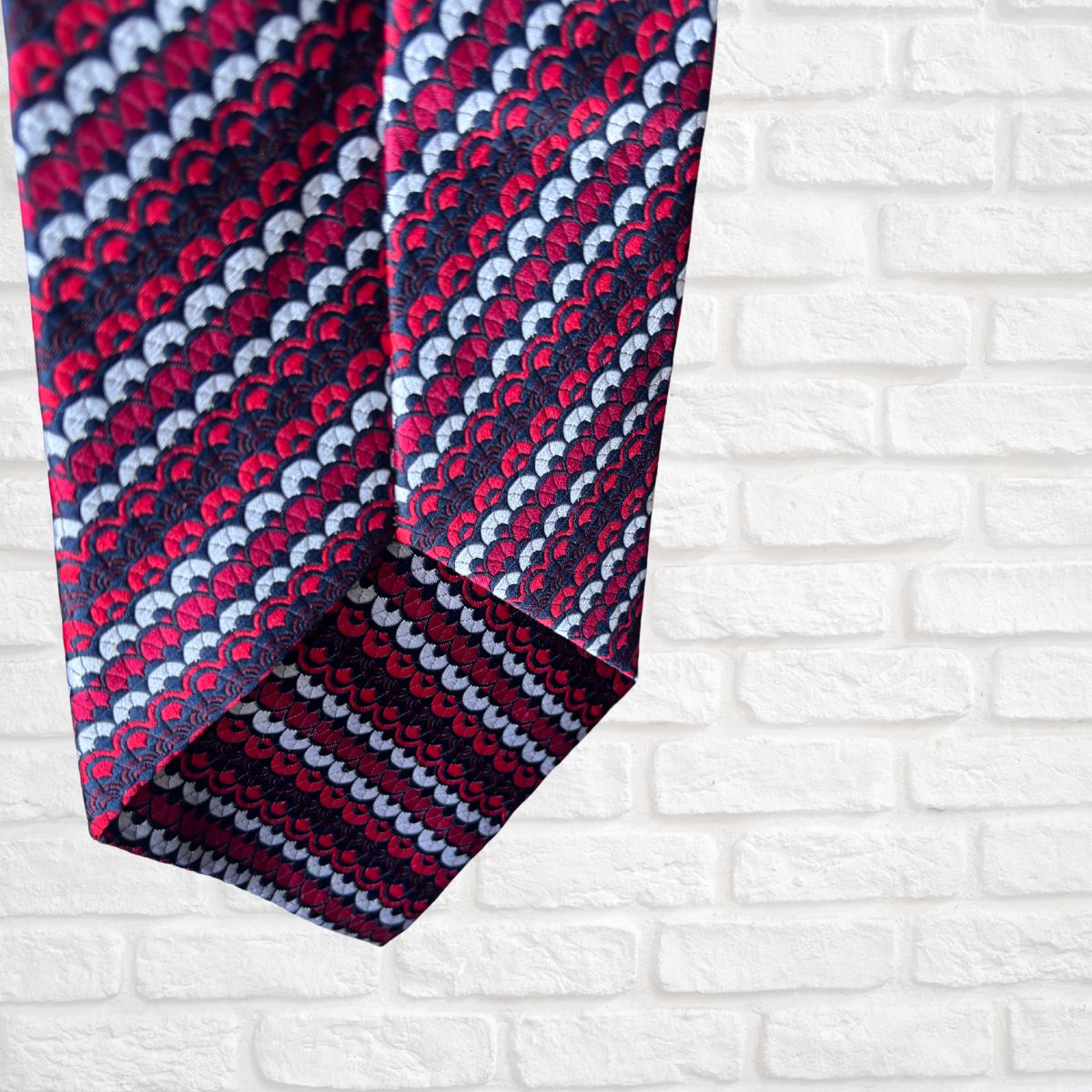 Patterned tie on a white brick wall background