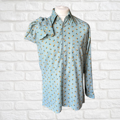 70s shirt  with a pattern on a mannequin against a white brick wall.