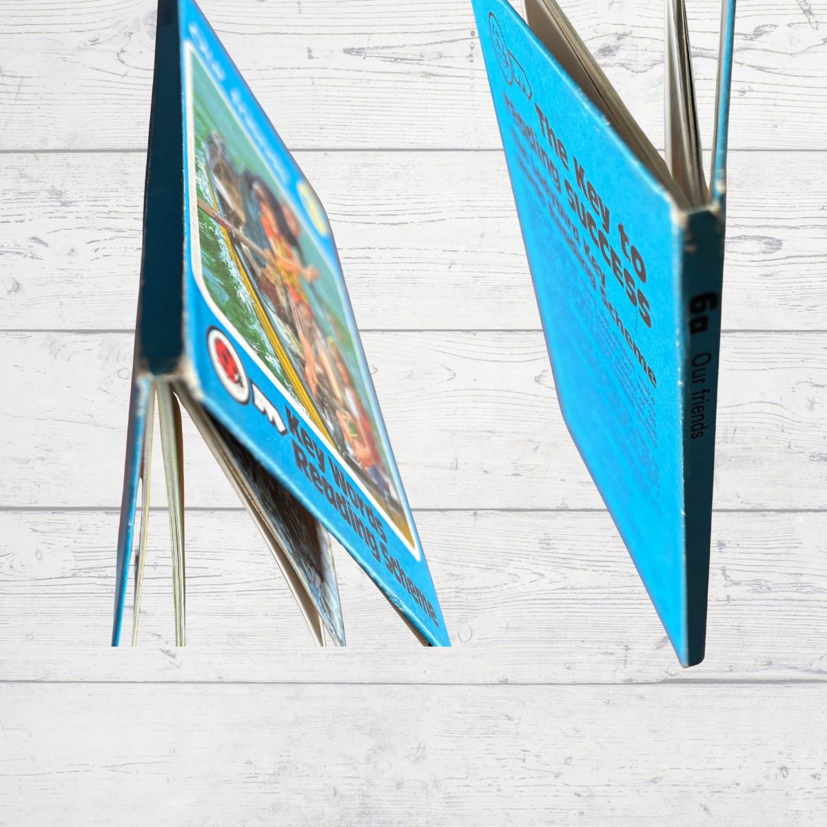 Open book with blue cover on a light wooden surface
