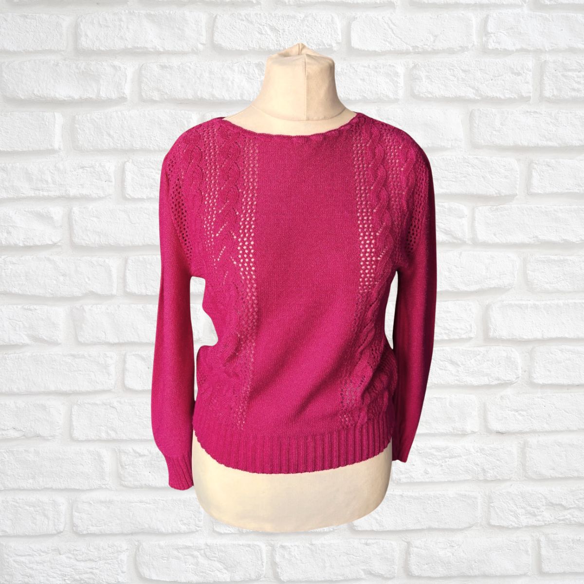 Pink sweater on a mannequin against a white brick wall background