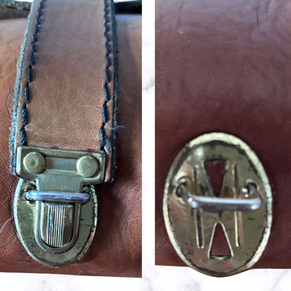 Close-up of a brown leather strap with a brass buckle on the left and an oval metal emblem on the right, shown in a two-panel detail view.
