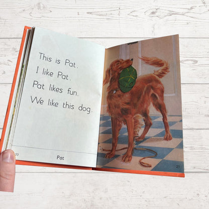 Open book showing a page with text and an illustration of a dog on a wooden surface