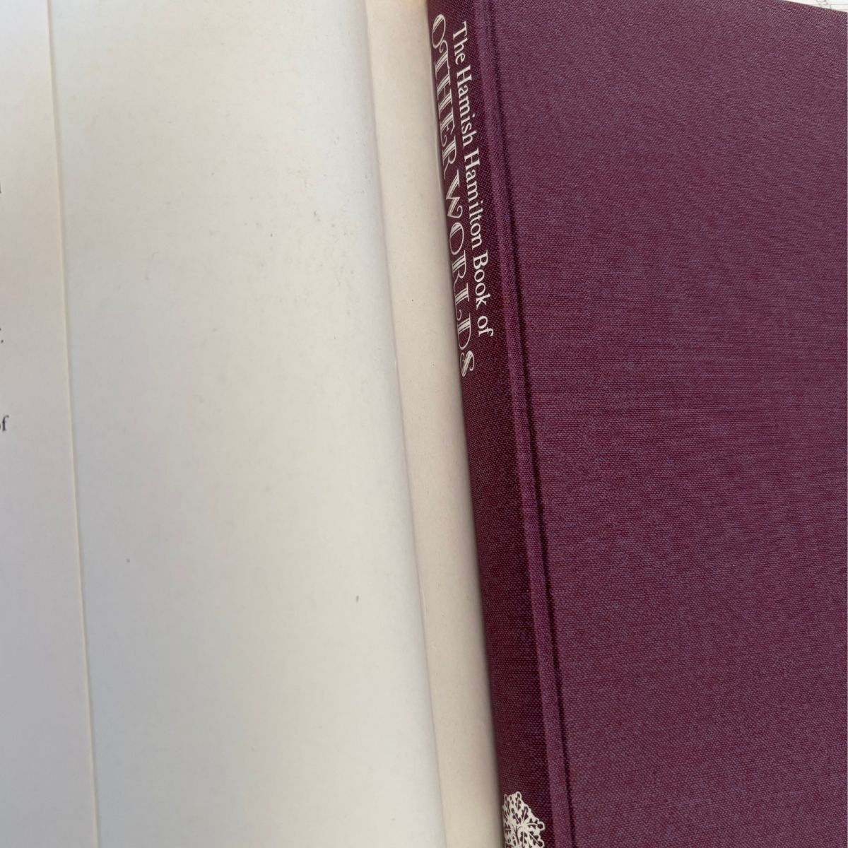 A close-up of a hardcover book with a textured burgundy-purple cover and cream spine, showing the title 'The Hamilton Hamilton Book of QUEENSLAND' printed vertically.