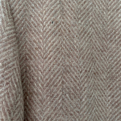 Close-up of a herringbone jacket in a warm taupe-beige color with subtle brown undertones.