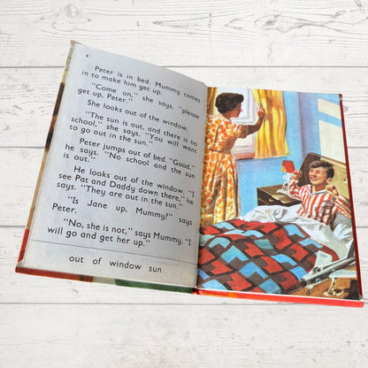 Open book with a colorful illustration of a child in bed and a parent by a window.