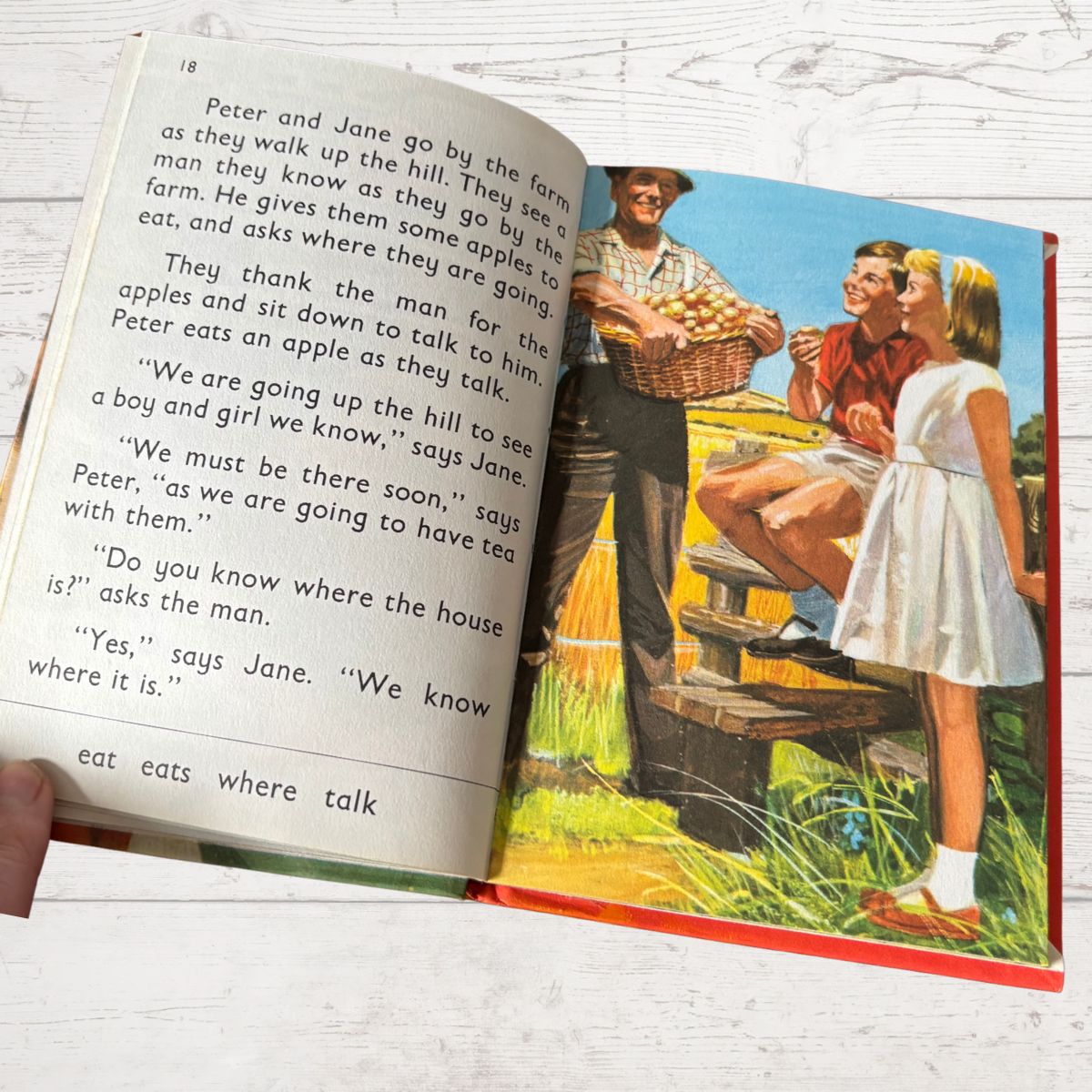 Open book with a vintage illustration of a family on a farm and text.