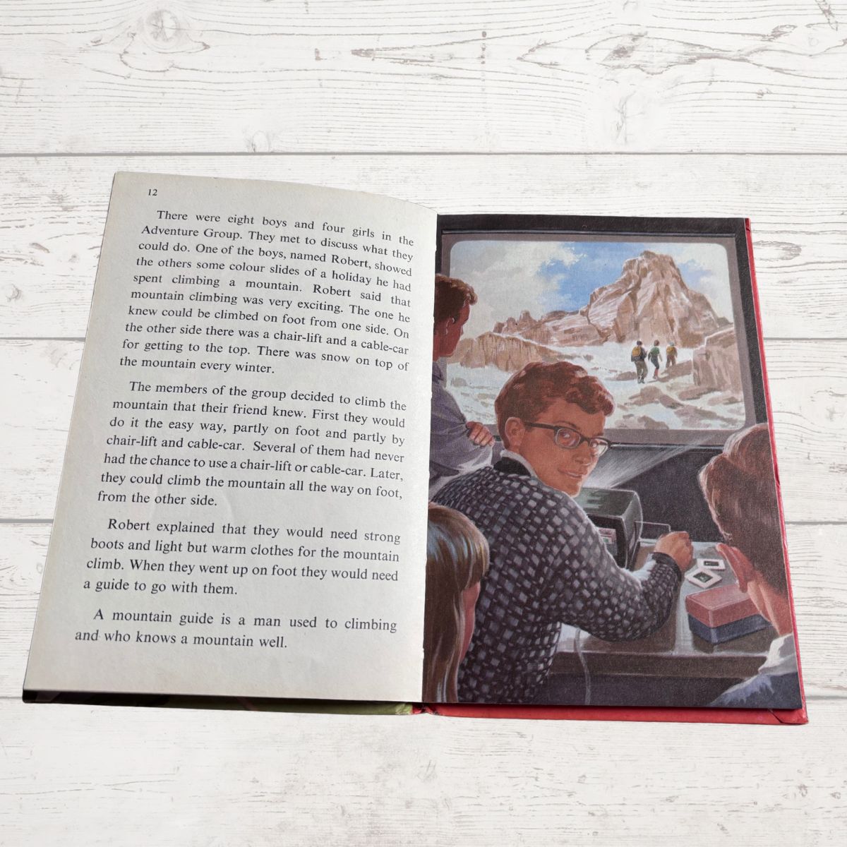 Open book with illustrations and text on a wooden surface