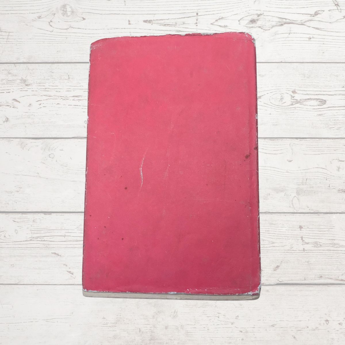 Red book on a light wooden surface