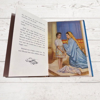 Open book with text and a colorful illustration on a wooden surface