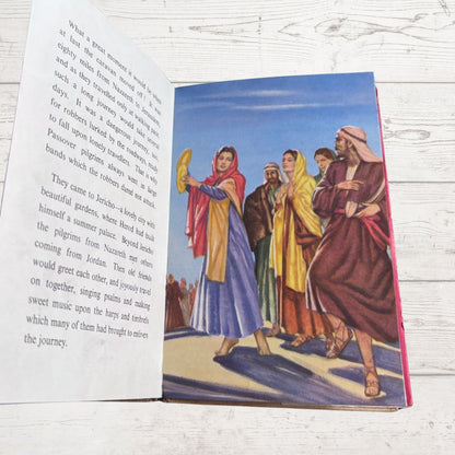 Open book with a colorful illustration of people on a wooden surface