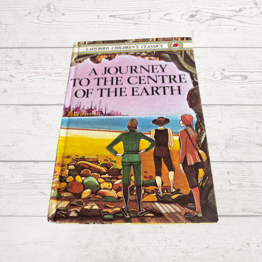 A vintage hardcover book titled 'A Journey to the Centre of the Earth' from the 'Lloyd Richard Children's Classics' series, displayed flat on a white-painted wooden surface.