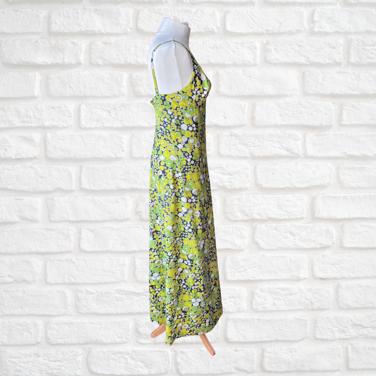 Floral dress on a mannequin against a white brick wall background