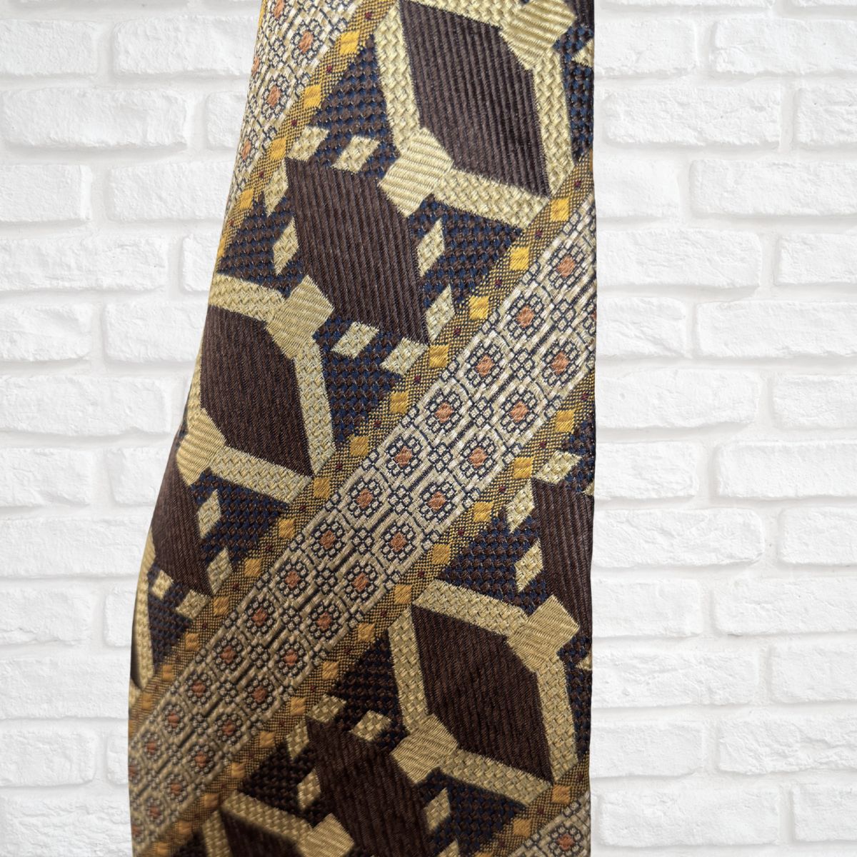 Patterned tie against a white brick wall background