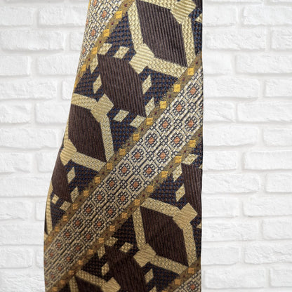 Patterned tie against a white brick wall background