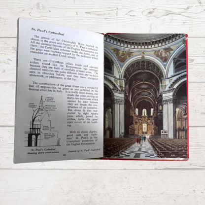 An open children's book showing a page about St. Paul's Cathedral with text, a line drawing, and a large color photograph of the cathedral interior, placed on a white wood surface.
