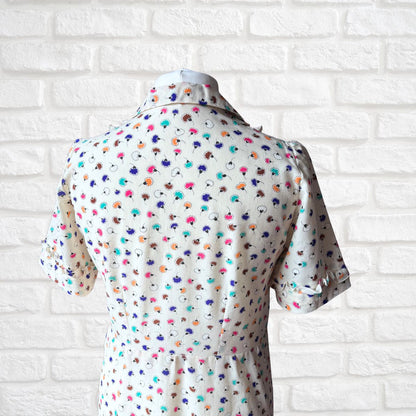 Short-sleeve dress with colourful pattern on a white brick wall background