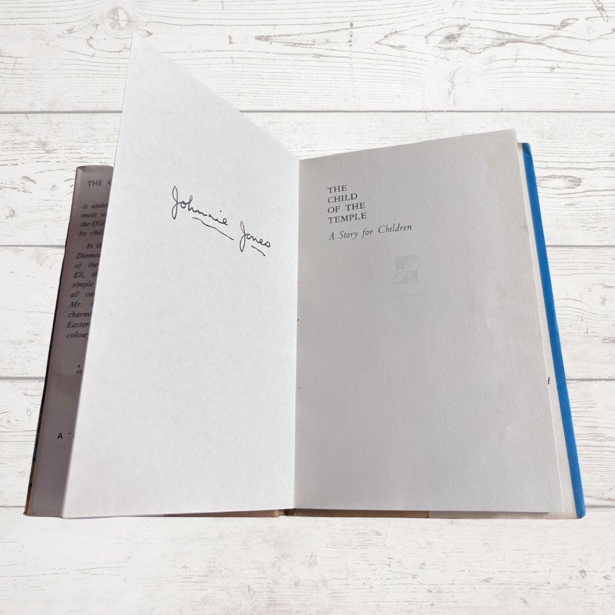Open book with text and inscription on a wooden surface