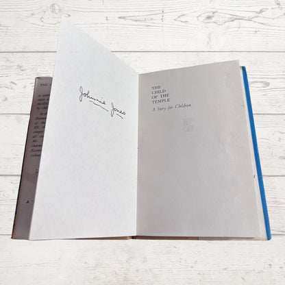 Open book with text and inscription on a wooden surface