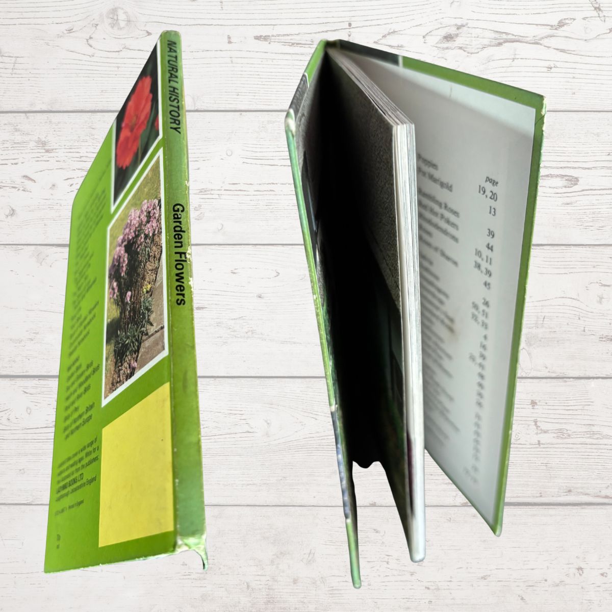 A hardcover book titled 'Garden Flowers: shown from multiple angles on a light wood background. The green cover features images of flowers, and the interior pages are visible.
