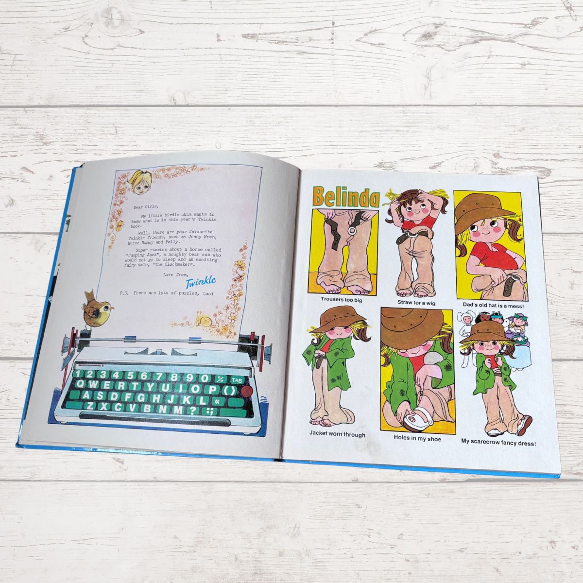 An open vintage-style book or magazine lying on a white wood surface, showing a handwritten letter page on the left and a six-panel cartoon comic on the right with the title 'Belinda'.