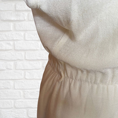 Close-up of beige fabric against a white brick wall