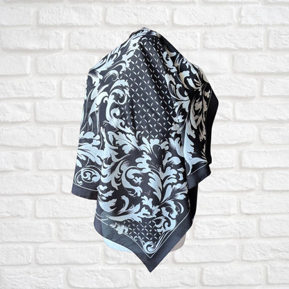 Black and white patterned scarf draped over a white brick wall