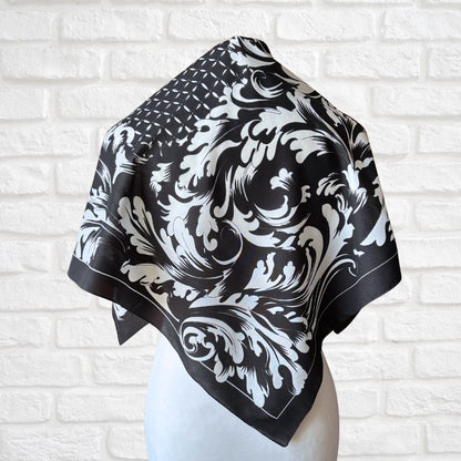Black and white patterned scarf on a mannequin against a white brick wall background