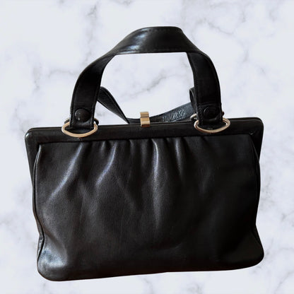 Black leather handbag on a light gray background