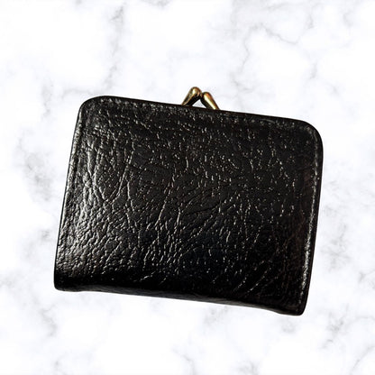 Black leather wallet on a white marble background