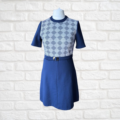 Blue dress with patterned top on a mannequin against a white brick wall background