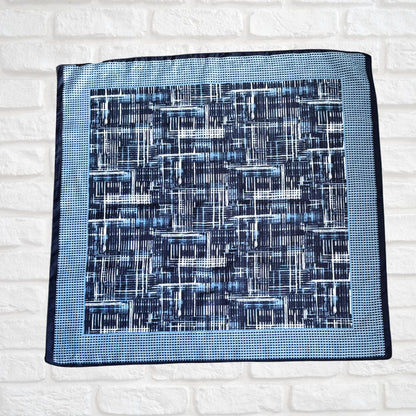 Blue patterned rea side of scarf on a white brick wall background