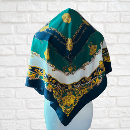 Decorative scarf with gold patterns on a white brick wall background