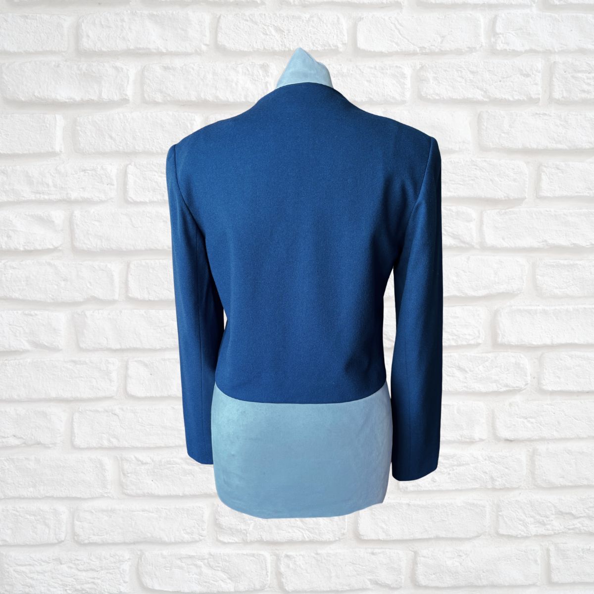 Blue jacket with a white brick background