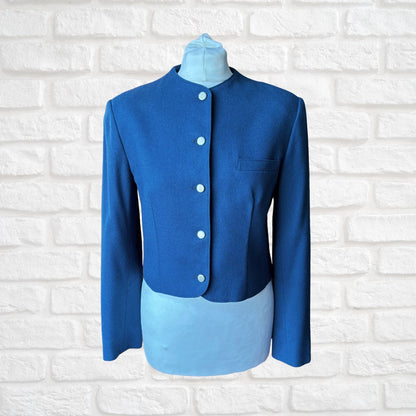 Blue jacket on a mannequin against a white brick wall background