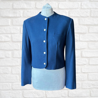 Blue jacket on a mannequin against a white brick wall background