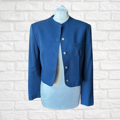 Blue blazer on a mannequin against a white brick wall background