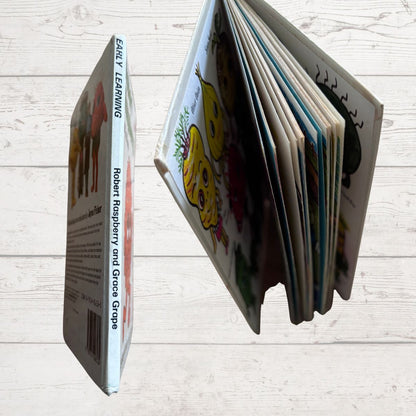 Children's book open to a page with colorful illustrations on a wooden surface