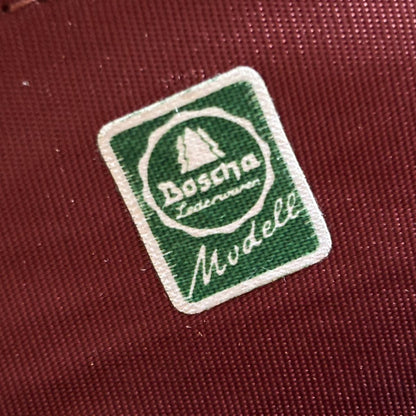 Close-up of a green and white logo on a red fabric background