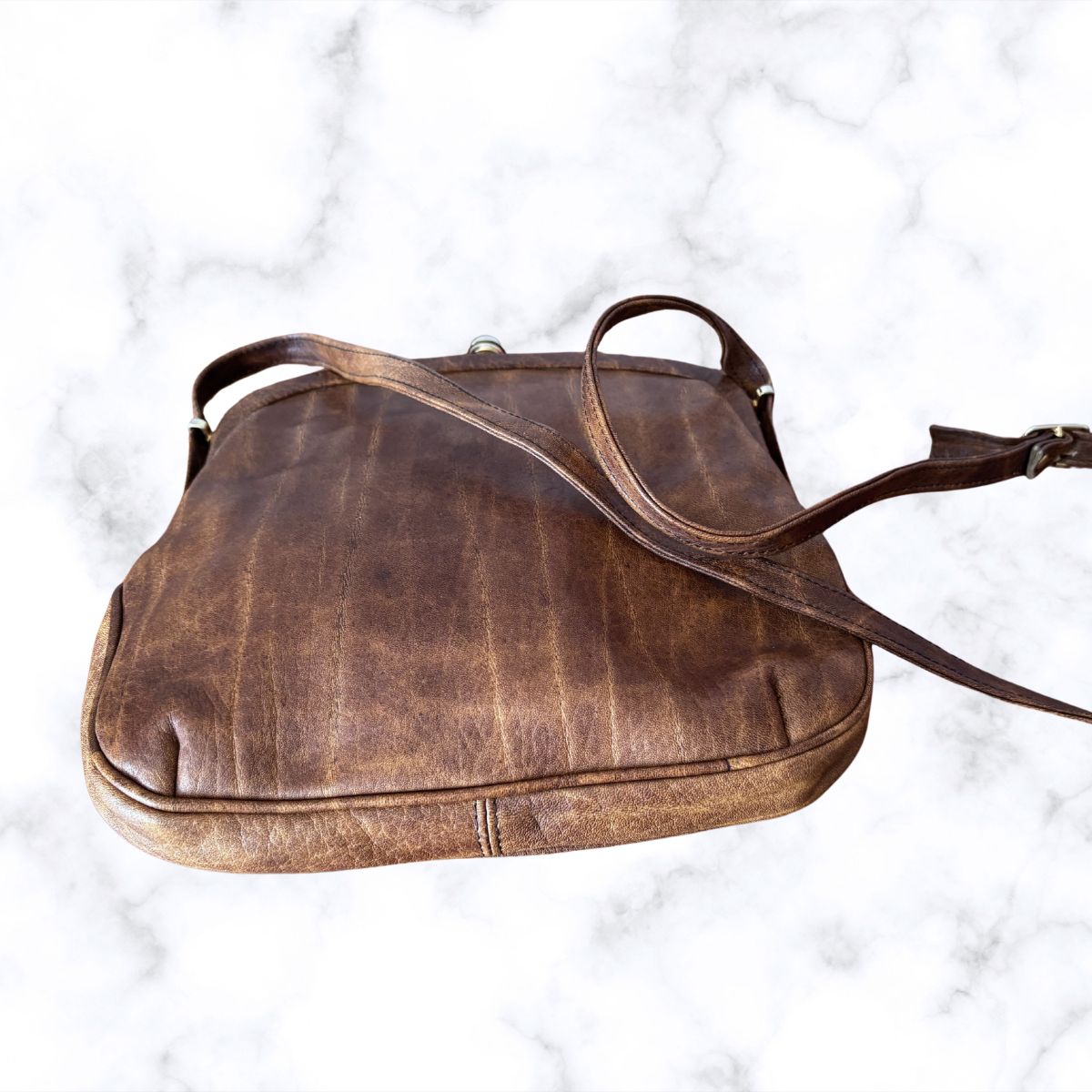 Brown leather look  bag on a white marble background