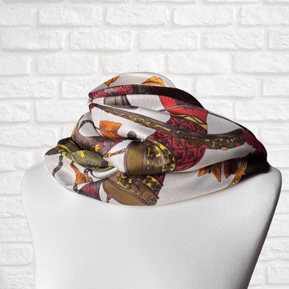 Colorful scarf with a pattern on a mannequin against a white brick wall background