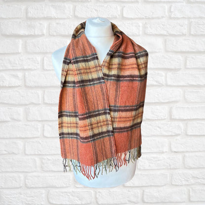 Plaid scarf on a mannequin against a white brick wall