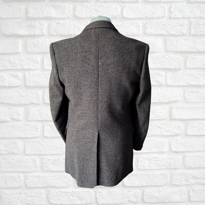 Brown  blazer on a mannequin against a white brick wall background
