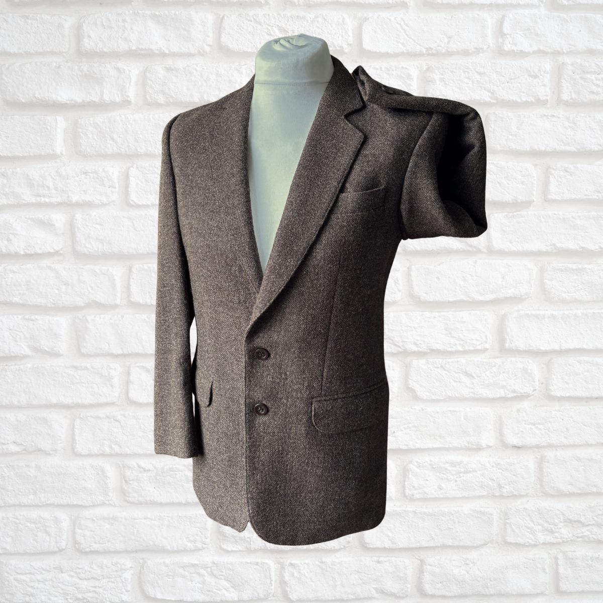 Brown  blazer on a mannequin against a white brick wall background