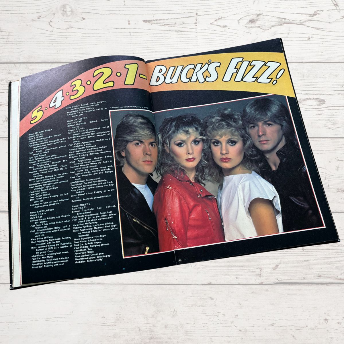 Open book with a photo of four people and text on a wooden surface