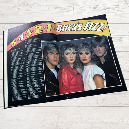 Open book with a photo of four people and text on a wooden surface