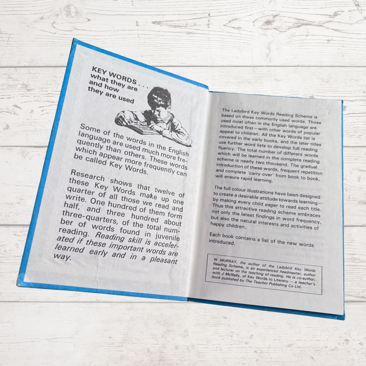 Open book with text and a picture of a boy on a wooden surface