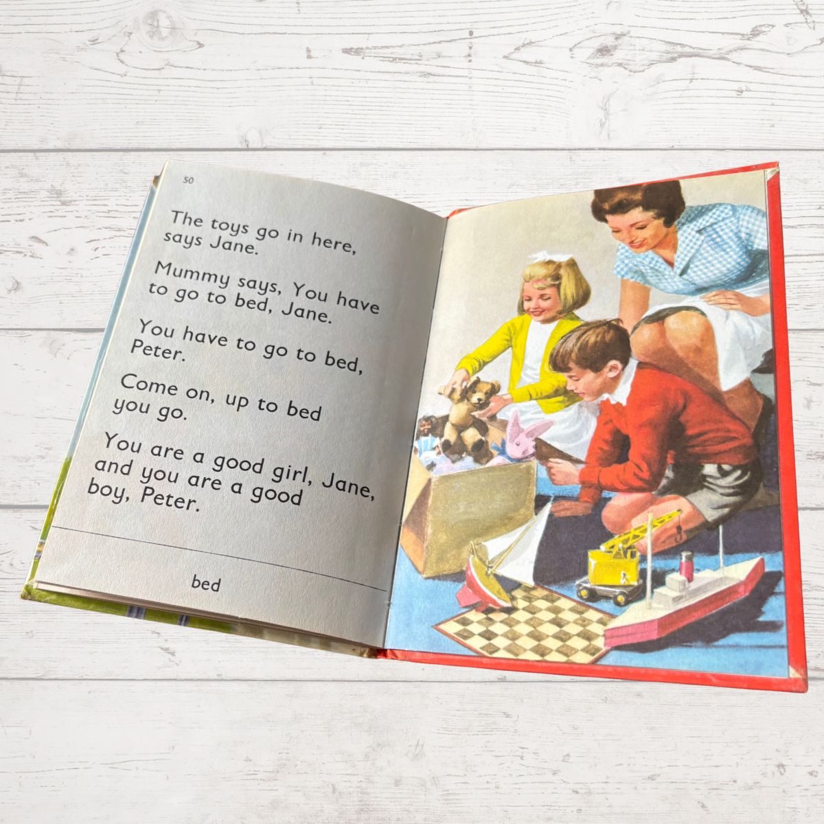 Open book with children's illustration and text on a wooden surface